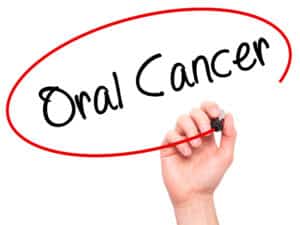 Man Hand writing Oral Cancer with black marker on visual screen. Isolated on background.