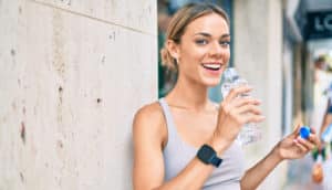 fitness woman wearing sport clothes training outdoors drinking fresh water