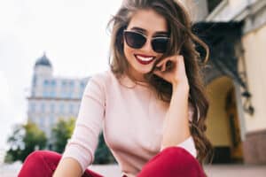Bottom view of attractive student girl in sunglasses with snow white smile
