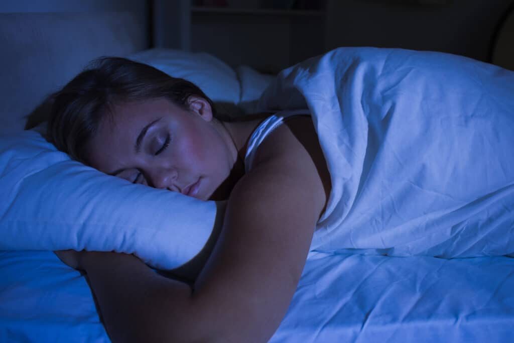 Woman hugs her pillow during a peaceful night of sleep.